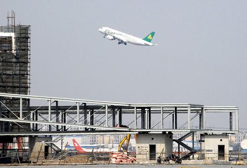 4月8日,一架飛機(jī)從正在施工的上海虹橋機(jī)場(chǎng)第二航站樓登機(jī)長(zhǎng)廊上空飛過(guò)。