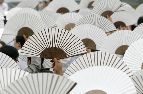 2008年6月19日,在韓國首都首爾,人們舉起一面面紙扇呼吁大家節(jié)約能源,保護(hù)地球。聯(lián)合國環(huán)境規(guī)劃署確定2009年“六·五”世界環(huán)境日的主題為“你的星球需要你,聯(lián)合起來應(yīng)對氣候變化”。 新華社發(fā)(于洋編輯)