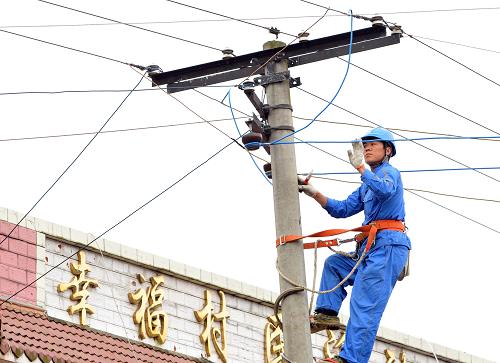6月12日,一名電力工人在搶險救援指揮部附近的一根電桿上檢查電線,以確保救援行動的電力供應(yīng)。