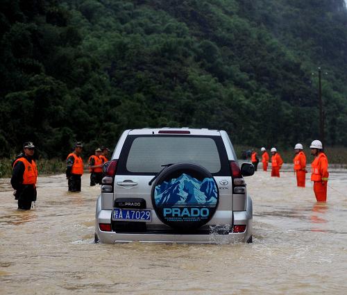 7月4日,武警和消防戰(zhàn)士用身體作路標(biāo)幫助過(guò)往車輛駛過(guò)被淹公路。 受連續(xù)暴雨影響,廣西羅城縣出現(xiàn)洪水、內(nèi)澇,全縣10多萬(wàn)人受災(zāi),數(shù)百間房屋倒塌。 新華社記者張愛林?jǐn)z