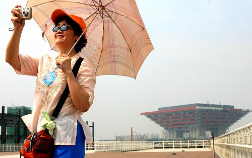 7月4日,來(lái)自上海市五里橋街道的居民高萌在世博會(huì)中國(guó)館建設(shè)工地外圍拍照留念。 7月5日,2010年中國(guó)上海世博會(huì)就將迎來(lái)開(kāi)幕倒計(jì)時(shí)300天。截至7月1日,累計(jì)已有191個(gè)國(guó)家和48個(gè)國(guó)際組織確認(rèn)參展上海世博會(huì)。目前,超過(guò)854萬(wàn)人次的上海社區(qū)居民參與了世博會(huì)知識(shí)培訓(xùn),報(bào)名上海世博會(huì)志愿者的境內(nèi)外人士已突破32萬(wàn)。 新華社記者 陳飛 攝