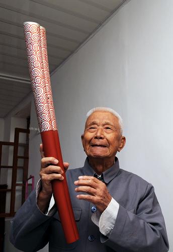 96歲參加過長征的老紅軍劉家祁在談2008年當(dāng)上奧運火炬手的感受(7月3日攝)。 紅色,是這片土地炫目的符號。 紅色,是這座小城永遠的圖騰。 紅色的土地,紅色的建筑,紅色的星徽,還有大街小巷飄揚的中華蘇維埃共和國國旗和中華人民共和國國旗,無不輝映著她昨天的歷史和今天的光榮。 在共和國六十華誕的日子里,我們走進了共和國搖籃——瑞金,一座被赤色浸潤血脈深處的紅色故都。 新華社記者馬平攝