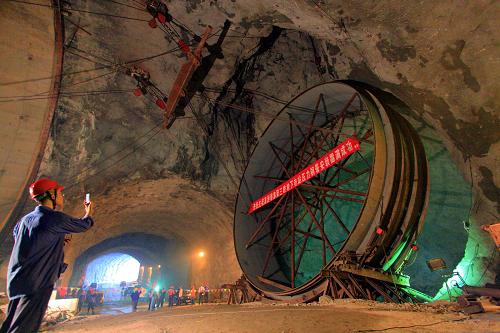 三峽地下電站最后一節(jié)引水壓力鋼管成功安裝 9月20日,一名建設(shè)者用手機拍攝三峽工程地下電站2號機組最后一節(jié)引水壓力鋼管安裝過程。 當(dāng)日,三峽工程地下電站2號機組最后一節(jié)引水壓力鋼管在工程技術(shù)人員的精心操作下,下滑安裝到位,標(biāo)志著三峽地下電站引水壓力鋼管全部安裝結(jié)束。據(jù)了解,作為引水發(fā)電的重要設(shè)備,三峽地下電站六臺機組的引水洞共安裝6條壓力鋼管,每條壓力鋼管由直徑為12.8米的49個管節(jié)組成,分下平段、錐管漸變段、下彎段和斜直段四部分,單節(jié)重約40至70噸不等。 新華社發(fā)(夏林 攝)