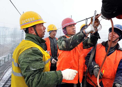 11月28日,在京九鐵路電氣化改造工程的施工現(xiàn)場,工人在安裝電氣化接觸網(wǎng)的懸掛裝置。