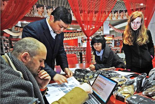 一家義烏民營針織企業(yè)外貿(mào)員工在和兩位俄羅斯客商談生意(2009年2月18日攝)。