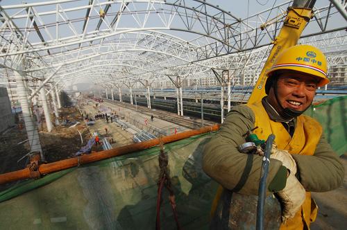 1月12日,建筑工人在合肥火車站站場里施工。