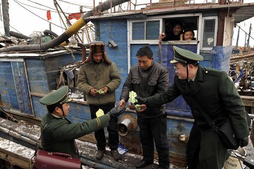 1月12日,萊州市海廟口邊防派出所干警為受困漁民送藥品。自2009年12月中旬以來,這個(gè)派出所已經(jīng)救助受困漁民200多人次。 新華社記者 朱崢 攝