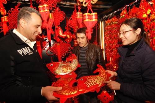 2月8日,一位埃及客商(左)在義烏國(guó)際商貿(mào)城采購(gòu)新春飾品。