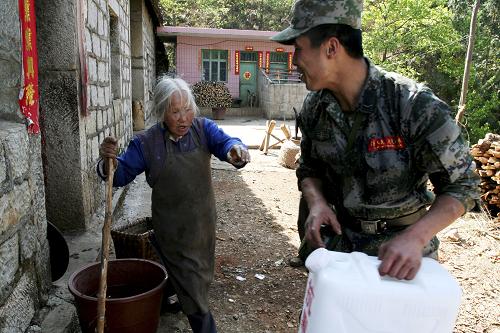 成都軍區(qū)某紅軍師官兵援黔抗旱保民生 4月4日,盤縣板橋鎮(zhèn)梅子沖村一名老人挽留為她送水的戰(zhàn)士在家吃飯。 成都軍區(qū)某紅軍師炮兵團某連在貴州省盤縣旱情嚴(yán)重的板橋鎮(zhèn)剛剛駐扎下來,就立即投入到抗旱救災(zāi)中,為飲水困難群眾送水、搶修水利設(shè)施、幫助群眾春耕搶種。 新華社發(fā)(黃蜀錦 攝)