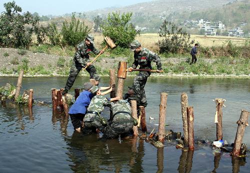 4月5日,在盤縣板橋鎮(zhèn)薛官屯村,解放軍官兵打樁筑河壩,幫助村民安裝水車灌溉農(nóng)田。 成都軍區(qū)某紅軍師炮兵團某連在貴州省盤縣旱情嚴(yán)重的板橋鎮(zhèn)剛剛駐扎下來,就立即投入到抗旱救災(zāi)中,為飲水困難群眾送水、搶修水利設(shè)施、幫助群眾春耕搶種。 新華社發(fā)(黃蜀錦 攝)