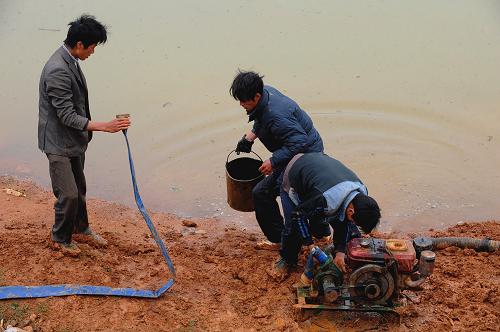 4月23日,戈衣村村民在已經(jīng)開始蓄水的戈衣水庫(kù)抽水。 在云南省陸良縣干旱重災(zāi)區(qū)大莫古鎮(zhèn)戈衣村,一口由昆明勘察設(shè)計(jì)院抗旱打井突擊隊(duì)奮戰(zhàn)20余天打出的200米深井,近日開始為干涸近半年的戈衣水庫(kù)供水,以備春耕生產(chǎn)急用。 新華社記者陳海寧攝