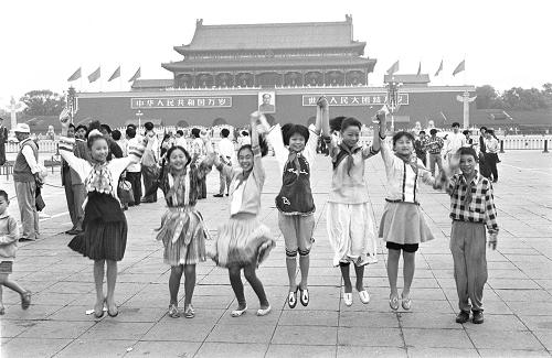 1995年6月1日,來自貴州貧困山區(qū)的7名品學(xué)兼優(yōu)的土家族、侗族小學(xué)生在北京天安門觀看升旗儀式后,歡呼雀躍。這7名小學(xué)生是應(yīng)北京西城區(qū)少年宮邀請(qǐng)來京與首都小學(xué)生進(jìn)行交流,共度國(guó)際兒童節(jié)的。 新華社記者唐召明攝 (資料照片)