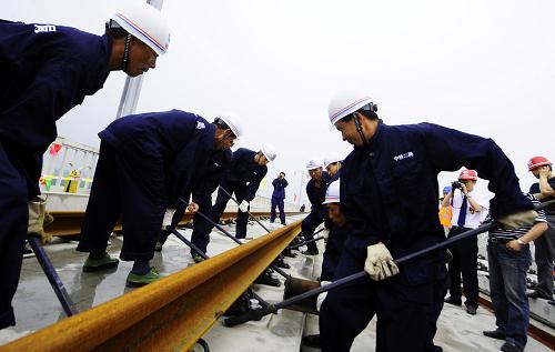 6月28日,中鐵二局的建設(shè)工人對正鋼軌位置。 當日,哈大鐵路客運專線首根鋼軌在中鐵二局營海特大橋開始鋪設(shè)。這標志著哈大客運專線建設(shè)進入最后的攻堅階段。新建鐵路哈爾濱至大連客運專線線路全長903.9公里,全線初步設(shè)計概算總投資980億元,共設(shè)哈爾濱、長春西、沈陽北、沈陽、新大連、大連等24個車站。按照目前的施工進度,有望在2011年4月底完成全線鋪軌任務(wù),在2011年底前,達到開通運營條件。 新華社記者任勇攝