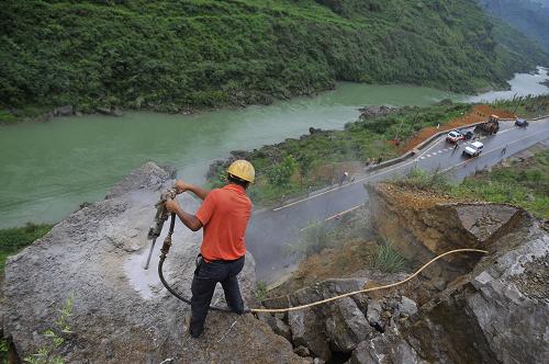貴州:清危石除隱患 7月10日,爆破人員在凱(里)施(秉)公路邊坡的危石上鑿孔,準(zhǔn)備實(shí)施爆破作業(yè)。 受近日持續(xù)強(qiáng)降雨影響,貴州省黔東南州凱里市境內(nèi)多條公路邊坡上出現(xiàn)不同程度的危石,危及過(guò)往車輛及行人的安全,凱里公路管理段組織爆破人員和機(jī)械設(shè)備力量及時(shí)清除,消除隱患。 新華社發(fā)(陳沛亮 攝)