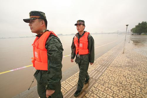 8月10日,兩名邊防武警戰(zhàn)士在鴨綠江丹東市城區(qū)段巡邏。 受持續(xù)強(qiáng)降雨和黃海年度最大潮汐影響,丹東鴨綠江水域水量暴漲,沿江各處均超過警戒水位。江水迅速漫進(jìn)鴨綠江公園和濱江路,公園樹木、綠地及沿江部分旅游設(shè)施被淹。丹東邊防支隊(duì)緊急調(diào)派警力,疏散涉險(xiǎn)群眾。 新華社發(fā)(戚萬鵬 攝)