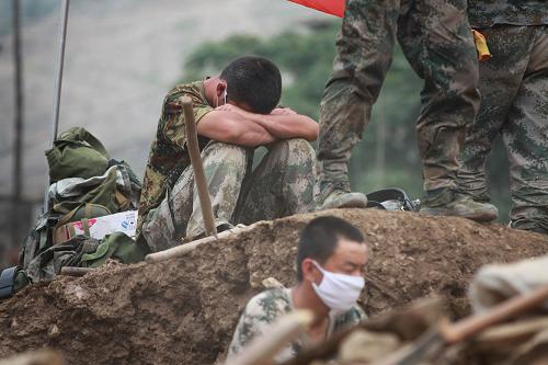 舟曲救災部隊加大搜救清淤排險防疫力度 8月11日,一名輪換下來的搶險士兵坐在廢墟上小憩。 當日,近萬名解放軍和武警官兵投入新一輪的搜救清淤排險工作。救災部隊在全力做好搜救生命,救治傷員的同時,重點做好堰塞湖排險、清淤和衛(wèi)生防疫等工作。 新華社記者 李剛攝