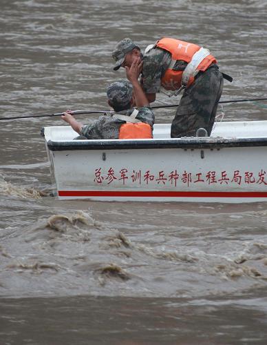 8月13日,現(xiàn)場(chǎng)組織爆破的工兵團(tuán)參謀長鄒俊良為作業(yè)中的戰(zhàn)士擦去臉上的汗水。 目前,經(jīng)過16名爆破勇士6天20余次的緊張爆破,舟曲特大泥石流災(zāi)害形成的堰塞湖堰塞體已消除。 這個(gè)堰塞湖一度使穿越舟曲縣城的白龍江河床平均上升8余米,洪水漫出河堤,沖擊江堤邊上的居民樓和商鋪。8月8日下午開始,蘭州軍區(qū)某部工兵團(tuán)地爆連16名官兵對(duì)白龍江堰塞體展開爆破。這是他們首次在水里執(zhí)行爆破任務(wù)。 江水湍急,炸藥不容易固定,戰(zhàn)士們就直接跳入洪水中安裝炸藥,下藥時(shí)只有雙膝跪著一步一步向前,水里的石頭、玻璃等堅(jiān)硬物體常常將膝蓋和雙腿刮破。此外,他們還要冒死排除啞炮。針對(duì)大裝藥爆破危險(xiǎn)大、效果不理想的問題,他們創(chuàng)造性地提出小號(hào)裝藥、多次爆破的方法,收效明顯。 新華社記者李剛攝