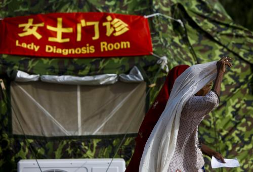 中國國際救援隊流動醫(yī)院開設“女士門診” 9月16日,在巴基斯坦南部受洪災最嚴重的特達地區(qū)馬克里鎮(zhèn),一名女病人走出中國國際救援隊流動醫(yī)院的“女士門診”。 正在巴基斯坦進行醫(yī)療救助的中國國際救援隊考慮到該國的風俗,特意在流動醫(yī)院內(nèi)建立了“女士門診”,專為婦女、兒童接診。三名來自武警總醫(yī)院的女醫(yī)生在志愿者翻譯的幫助下耐心問診,為眾多當?shù)貗D女、兒童患者診治疾病。 新華社記者 周磊 攝