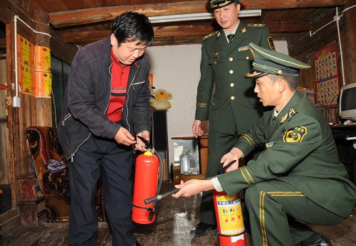 12月9日,兩名武警消防干部將滅火器送到苗族村民家中,并介紹使用方法。 當(dāng)日,貴州省公安廳、消防總隊(duì)等單位為位于貴州省黔東南州的西江千戶苗寨贈(zèng)送了一批滅火器材,幫助擁有1300多戶苗寨的西江苗寨提高防火滅火能力。近年來(lái),在各級(jí)政府和社會(huì)各界的幫助下,由大量傳統(tǒng)木結(jié)構(gòu)建筑組成的西江千戶苗寨裝配了一批消防栓、水槍、機(jī)動(dòng)泵等現(xiàn)代滅火裝備,改變了過去全靠從水缸挑水撲火的滅火方式,有效地控制住了“火燒連營(yíng)”等重大火災(zāi)的發(fā)生。 新華社記者 李勁峰 攝