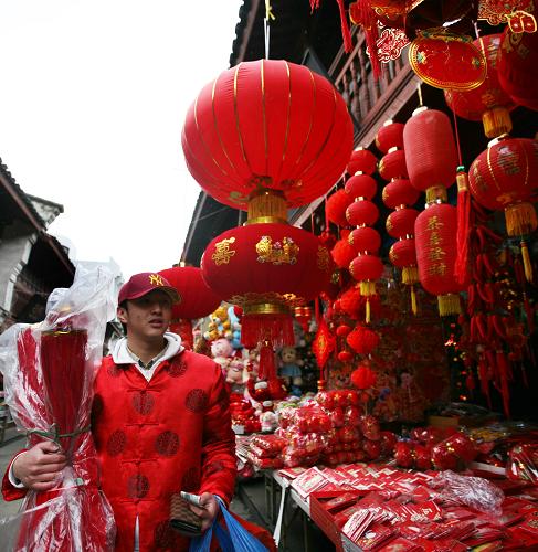 2月12日,一名剛從美國回國探親的青年身著唐裝,在浙江省舟山市西大街選購新春飾品。新華社發(fā)(胡社友 攝)