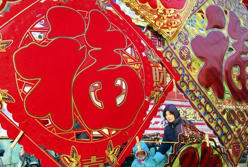 2月12日,祖孫二人在山東省淄博市周村街頭挑選喜慶飾品。農(nóng)歷虎年春節(jié)將至,周村街頭一派喜氣洋洋,人們忙著置辦燈籠、“福”字、春聯(lián)等喜慶飾品,紅紅火火過大年。新華社發(fā)(董乃德 攝)