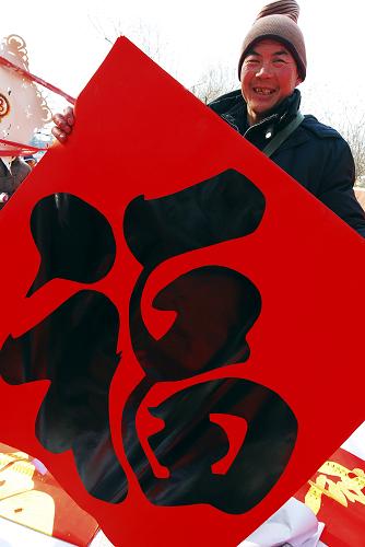2月12日,在山東省淄博市周村街頭,一位市民準備把買到的“福”字帶回家。農(nóng)歷虎年春節(jié)將至,周村街頭一派喜氣洋洋,人們忙著置辦燈籠、“福”字、春聯(lián)等喜慶飾品,紅紅火火過大年。新華社發(fā)(董乃德 攝)