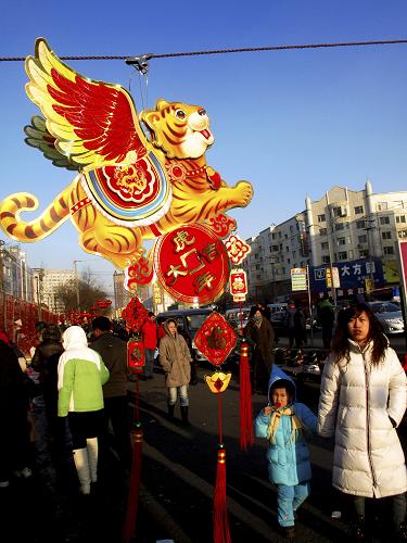 2月12日,在吉林市街頭,市民從長著翅膀的卡通虎飾品旁走過。新華社發(fā)(朱萬昌 攝)
