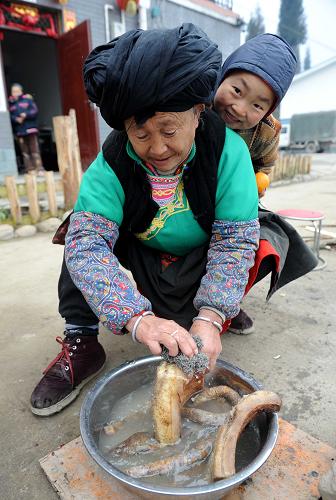 2月13日,在邛崍市南寶山永久安置點(diǎn),一位羌族阿媽正在洗臘肉。新華社記者 陳燮 攝