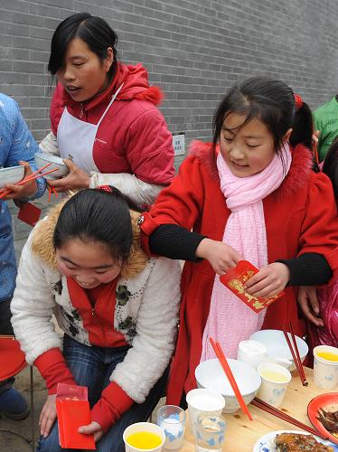 2月13日,在邛崍市南寶山永久安置點(diǎn),兩個(gè)小姑娘拿到了過年紅包。新華社記者 陳燮 攝