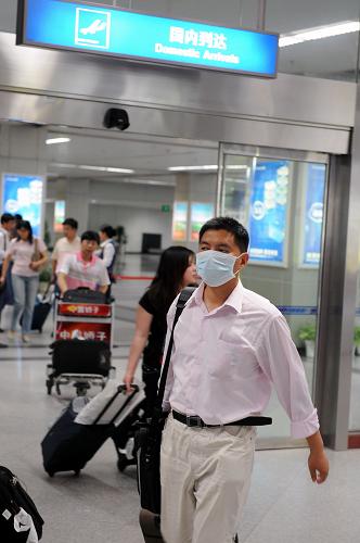 5月24日,一位戴著口罩的旅客走出福州長樂國際機(jī)場。新華社記者 姜克紅 攝