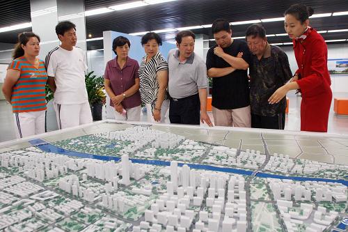 7月13日,在天津市天鋼柳林地區(qū)城市副中心的展示模型前,工作人員為前來參觀的市民講解。新華社發(fā) (劉東岳 攝)