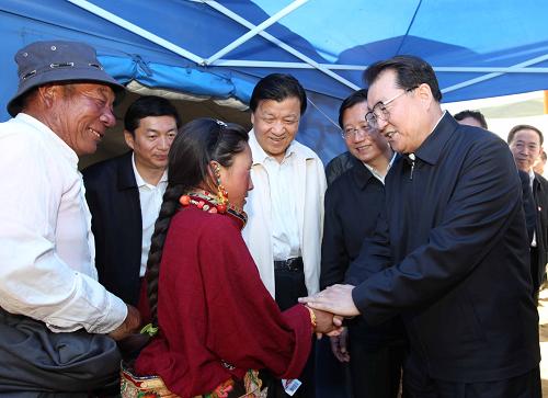 7月2日,李長春來到藏族老人羅西(左一)家的救災(zāi)帳篷,了解他們的生活情況,鼓勵家中的孩子好好學(xué)習(xí),長大為國家多做貢獻(xiàn)。新華社記者 劉衛(wèi)兵 攝