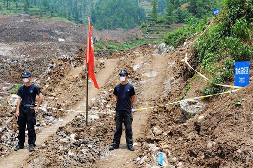 兩名特警在關(guān)嶺特大地質(zhì)災(zāi)害現(xiàn)場警戒(7月4日攝)。7月4日起,鑒于衛(wèi)生防疫工作壓力越來越大,當(dāng)?shù)爻掷m(xù)高溫,失蹤者已無生還可能等原因,貴州關(guān)嶺“6·28”特大地質(zhì)災(zāi)害現(xiàn)場搜救工作被迫中止,轉(zhuǎn)入局部搶險與衛(wèi)生防疫、受災(zāi)群眾安置及災(zāi)后重建相結(jié)合的階段。42名遇難者遺體在經(jīng)過DNA取樣后,開始在安順陸續(xù)火化。新華社記者 劉續(xù) 攝