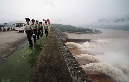 7月11日,武警官兵加強(qiáng)三峽大壩壩上巡邏。當(dāng)日凌晨,今年長(zhǎng)江入汛以來(lái)的首次洪峰到達(dá)三峽大壩。中國(guó)長(zhǎng)江三峽集團(tuán)公司實(shí)測(cè)結(jié)果顯示,上午此次洪峰的最大流量達(dá)38500立方米/秒,為今年三峽最大入庫(kù)流量。 三峽大壩由于攔蓄洪水,壩前水位已由10日12時(shí)的145.91米提升至146.78米。據(jù)初步測(cè)算,這一天時(shí)間,三峽工程為減輕長(zhǎng)江中下游防汛壓力攔蓄了約4.5億立方米的洪水。 自10日12時(shí)起,大壩開(kāi)啟1個(gè)排漂孔和3個(gè)泄洪深孔泄洪,出庫(kù)流量控制在32000立方米/秒以內(nèi)。在泄洪的同時(shí),利用庫(kù)容發(fā)揮防洪攔蓄作用。新華社發(fā)(李開(kāi)勇 攝)