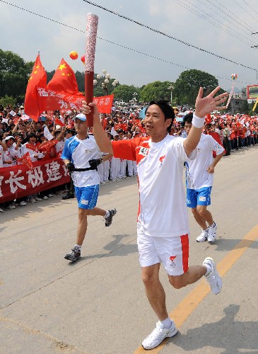 5月13日,火炬手蔡金輝在進(jìn)行傳遞。當(dāng)日,北京奧運(yùn)會(huì)圣火在福建省龍巖市上杭縣古田鎮(zhèn)傳遞。 新華社記者 姜克紅 攝