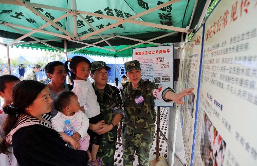 5月21日,南京軍區(qū)赴災(zāi)區(qū)醫(yī)療隊駐守什邡市受災(zāi)群眾安置點(diǎn)的軍醫(yī)在為受災(zāi)群眾講解防疫知識。 汶川地震發(fā)生后,南京軍區(qū)第85醫(yī)院組織64人的專家隊伍,攜帶整套野戰(zhàn)醫(yī)院裝備,于5月14日抵達(dá)四川什邡災(zāi)區(qū),救治傷員、照顧病人、組織防疫。目前,他們已經(jīng)在受災(zāi)群眾安置點(diǎn)廣泛展開衛(wèi)生防疫宣傳、組織工作。 新華社記者 姜帆 攝