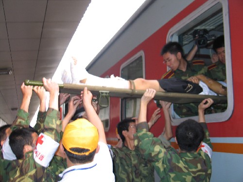 5月21日,第四軍醫(yī)大學(xué)組織的擔(dān)架隊(duì)員、護(hù)理隊(duì)員將傷員從火車上抬下來。 當(dāng)日6時(shí)58分,載著248名四川地震災(zāi)區(qū)重傷員的專列抵達(dá)西安火車站,這批傷員被迅速轉(zhuǎn)運(yùn)到西京醫(yī)院和唐都醫(yī)院。這是汶川地震發(fā)生后被送往陜西省進(jìn)行救治的首批重傷員。 新華社記者許祖華攝
