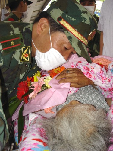 5月22日,一名武警俯下身安撫一位受傷的老人。 當(dāng)日,一列搭載著汶川大地震災(zāi)區(qū)300名傷員的專列抵達(dá)貴州省遵義市,其中100名傷員將在遵義醫(yī)學(xué)院附屬醫(yī)院接受治療,他們中年齡最大的83歲,最小的僅7個(gè)月大。 新華社發(fā)(王鴻 攝)