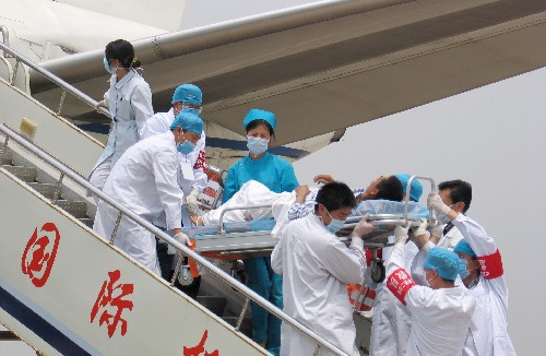 5月22日,山東大學(xué)第二醫(yī)院的醫(yī)務(wù)人員將傷員抬下舷梯。當(dāng)日11時(shí)50分,第一批36名四川地震災(zāi)區(qū)傷員抵達(dá)濟(jì)南機(jī)場(chǎng)。據(jù)了解,當(dāng)日共將有144名傷員從成都分乘4個(gè)航班,飛抵濟(jì)南、青島兩市接受治療。 新華社記者 王海鷹攝