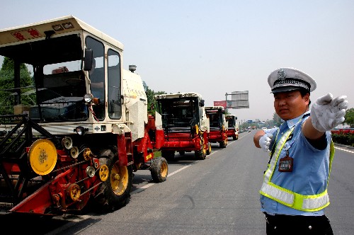 5月22日,河南濟(jì)源交警在為“麥客”指引道路。 5月中旬以來,眾多南下參加麥?zhǔn)盏?#8220;麥客”途經(jīng)河南省濟(jì)源市。當(dāng)?shù)亟痪跒?#8220;麥客”搞好服務(wù)的同時,特別提醒“麥客”注意交通安全。 新華社發(fā)(苗秋鬧 攝)