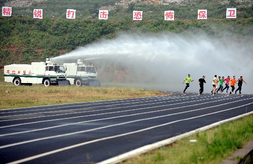 7月2日,武警戰(zhàn)士在演示用高壓水炮車沖散擾亂人群?! ‘?dāng)日,武警山東省總隊在訓(xùn)練基地舉行奧運安保反恐新裝備演示,旨在檢驗武警部隊在奧運會期間防范、處置恐怖襲擊事件的應(yīng)急反應(yīng)能力。 新華社記者 范長國攝
