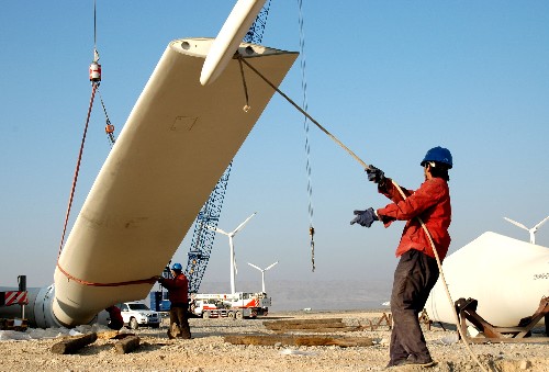 11月26日,施工人員在新疆吐魯番風力發(fā)電場吊裝風機。 新華社發(fā)(劉健 攝)