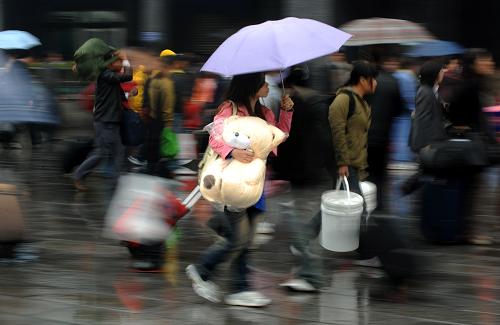 12月28日,在廣州火車站廣場(chǎng),旅客在細(xì)雨中快步前行。日前在廣州舉行的2009年廣東省春運(yùn)工作聯(lián)席會(huì)議介紹:盡管部分外來(lái)務(wù)工人員已提前返鄉(xiāng),但2009年春運(yùn)期間廣東全省客流量仍會(huì)比2008年增長(zhǎng)0.7%,預(yù)測(cè)超過1.38億人次。新華社記者 劉大偉攝