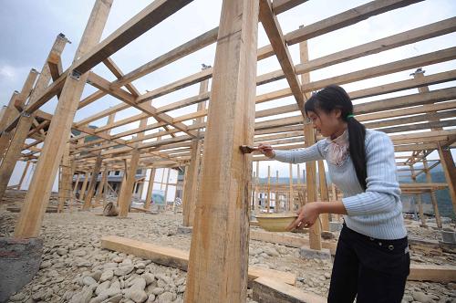 5月6日,青川縣板橋鄉(xiāng)浮寨村災(zāi)后農(nóng)房重建示范點,一位村民正在給房屋柱子上桐油。四川省青川縣是“5·12”地震重災(zāi)區(qū),受災(zāi)面積廣,房屋受損嚴重。青川群眾積極投身重建家園,目前該縣3.2萬戶居民完成了重建任務(wù),占重建規(guī)劃的60%,不少群眾搬進了新建房屋,過上安樂的生活。新華社記者 李曉果 攝