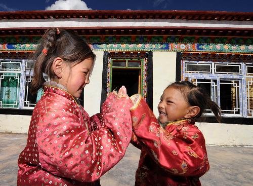 9月9日,西藏當(dāng)雄縣格達(dá)鄉(xiāng)羊易村兩個孩子在新房前玩耍。新華社記者 覺果 攝
