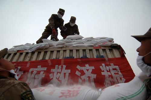 4月25日,在青海省玉樹縣巴塘鄉(xiāng),武警官兵將政府救濟(jì)糧從車上卸下。 新華社記者 張宏祥 攝