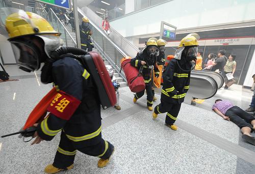 5月26日,消防搶險(xiǎn)隊(duì)員攜帶各種儀器和設(shè)備迅速進(jìn)入地鐵“火災(zāi)”現(xiàn)場。新華社記者 孫參 攝