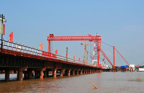 安慶長(zhǎng)江鐵路大橋工地(8月17日攝)。截至本月中旬,安徽省境內(nèi)的安慶長(zhǎng)江鐵路大橋工程已提前完成過半。安慶長(zhǎng)江鐵路大橋是寧安城際鐵路和阜陽至景德鎮(zhèn)鐵路的重要組成部分,全長(zhǎng)2996.8米,主跨達(dá)580米。大橋自2009年3月20日開工建設(shè),已用計(jì)劃工期的三分之一完成約58%的工程量。新華社記者 許逆之 攝