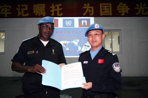 11月27日,在海地首都太子港,中國第五支駐海地維和警察防暴隊(duì)政委胡運(yùn)旺(右)從聯(lián)合國駐海地穩(wěn)定特派團(tuán)(聯(lián)海團(tuán))維和警察總警監(jiān)瑪瑪度·迪亞洛手中接過嘉獎(jiǎng)令。當(dāng)天,瑪瑪度·迪亞洛向即將結(jié)束維和任務(wù)的中國第五支駐海地維和警察防暴隊(duì)頒發(fā)嘉獎(jiǎng)令,以表彰這支隊(duì)伍在海地執(zhí)行聯(lián)合國維和任務(wù)中做出的突出貢獻(xiàn)。 新華社發(fā)(陳陽紅 攝)