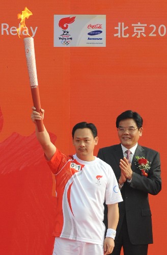 5月17日,第一棒火炬手、奧運冠軍占旭剛(左)在起跑儀式上展示火炬。當日,北京奧運會圣火在浙江溫州傳遞。新華社記者 王定昶 攝
